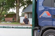 Geschaeftsfuehrer legt Holz auf Lkw
